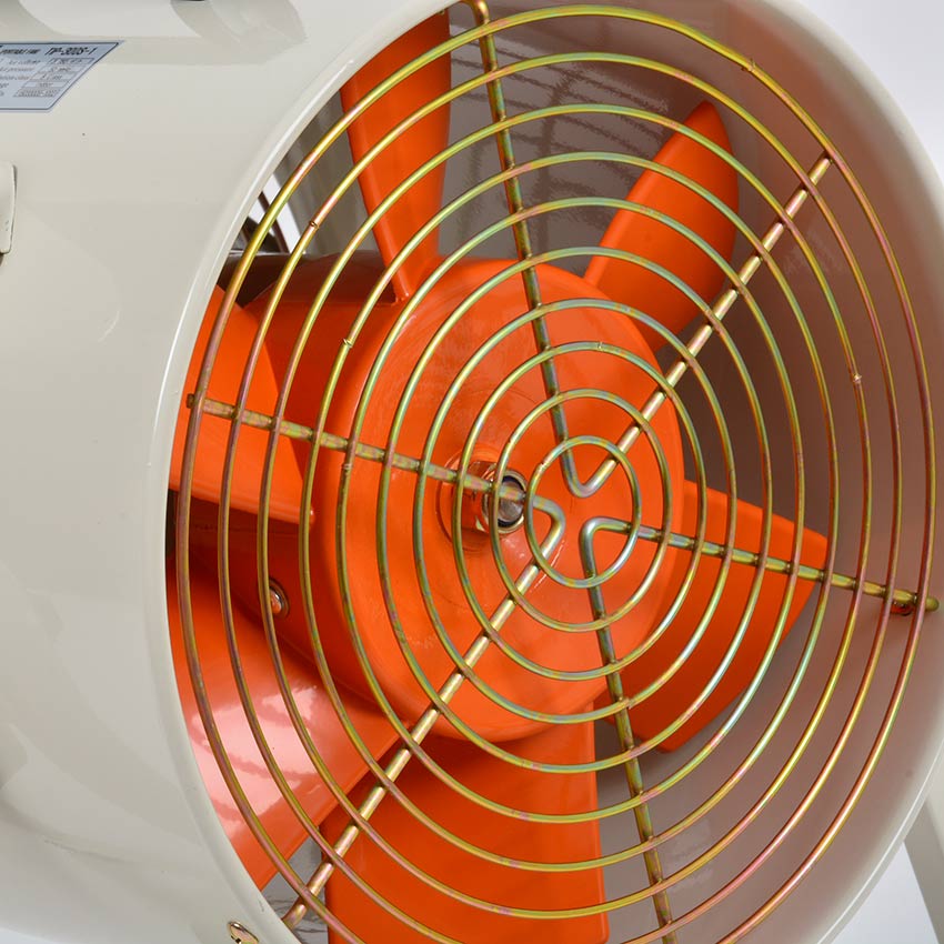 Close-up of a fan with orange blades and metal grill